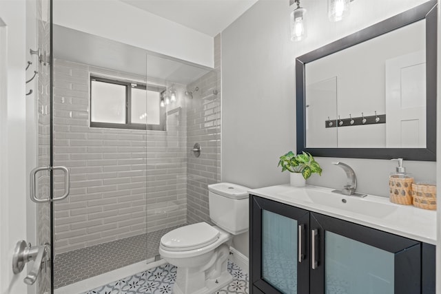 bathroom featuring tile patterned floors, vanity, toilet, and a shower with door