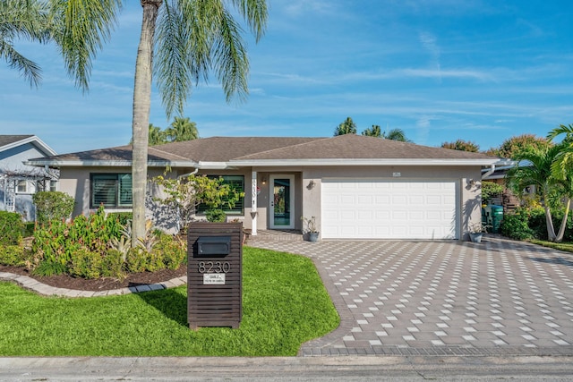 ranch-style home with a garage and a front lawn