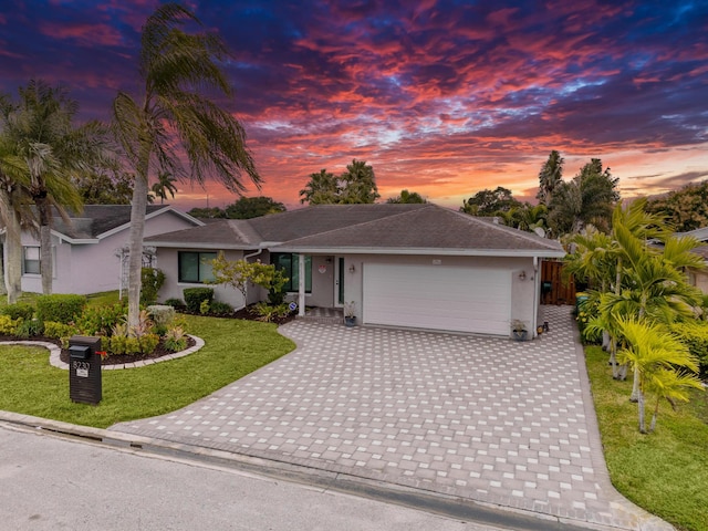 view of front facade with a garage and a lawn