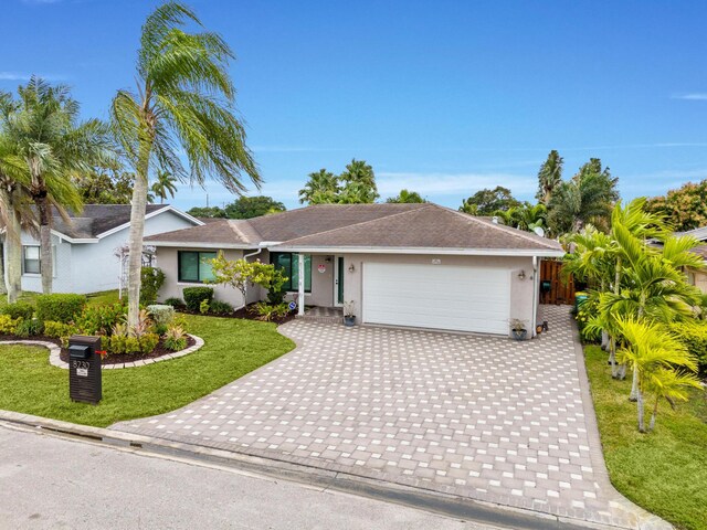 ranch-style home with a garage and a front yard