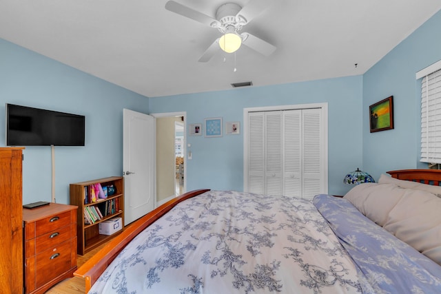 bedroom with hardwood / wood-style floors, a closet, and ceiling fan