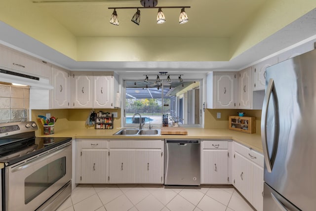 kitchen with white cabinetry, appliances with stainless steel finishes, sink, and light tile patterned floors