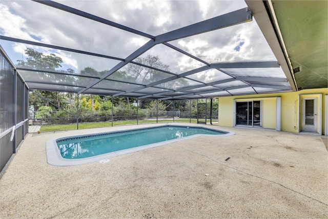 view of swimming pool featuring a patio area and glass enclosure