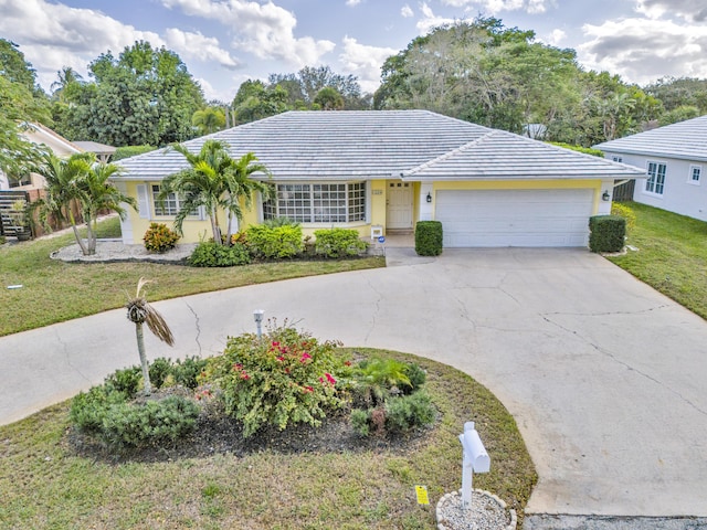 single story home featuring a garage and a front yard