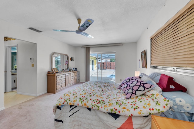 bedroom featuring ceiling fan, light colored carpet, a textured ceiling, and access to outside