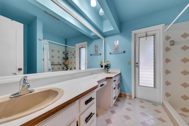 bathroom with vanity, curtained shower, and a healthy amount of sunlight