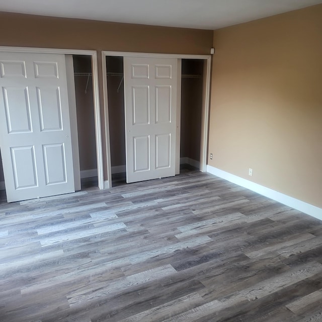 unfurnished bedroom with multiple closets and light hardwood / wood-style floors