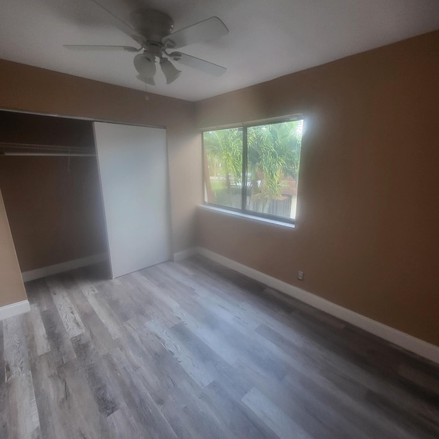 unfurnished bedroom with ceiling fan, a closet, and light hardwood / wood-style flooring