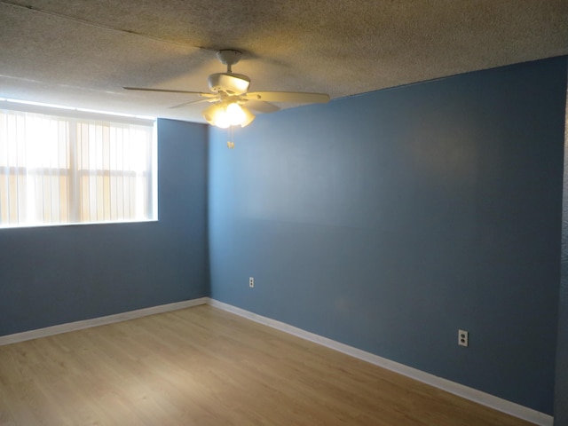 empty room featuring ceiling fan, hardwood / wood-style floors, and a textured ceiling