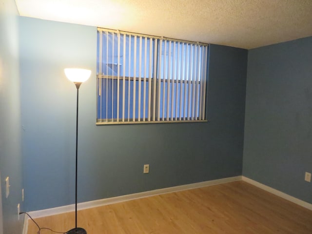 spare room with hardwood / wood-style flooring and a textured ceiling