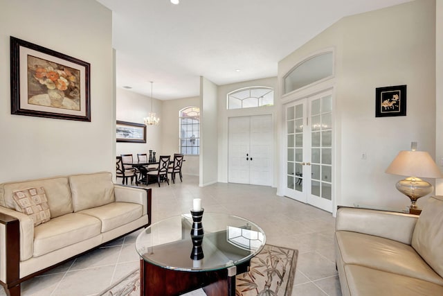 living room featuring french doors, light tile patterned flooring, and a notable chandelier