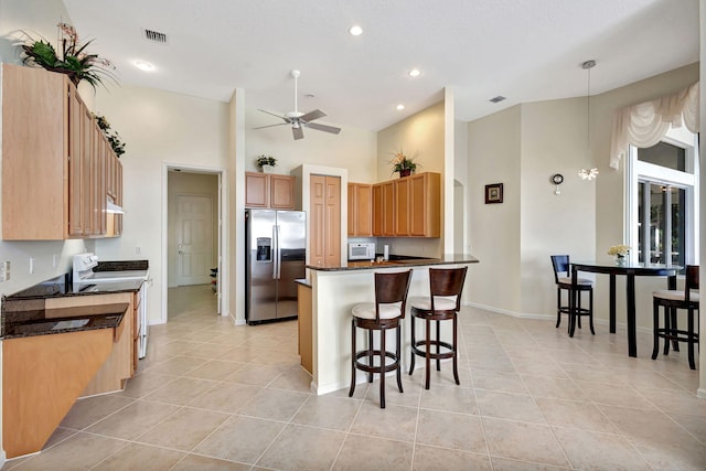 kitchen with range, decorative light fixtures, light tile patterned floors, stainless steel fridge, and ceiling fan