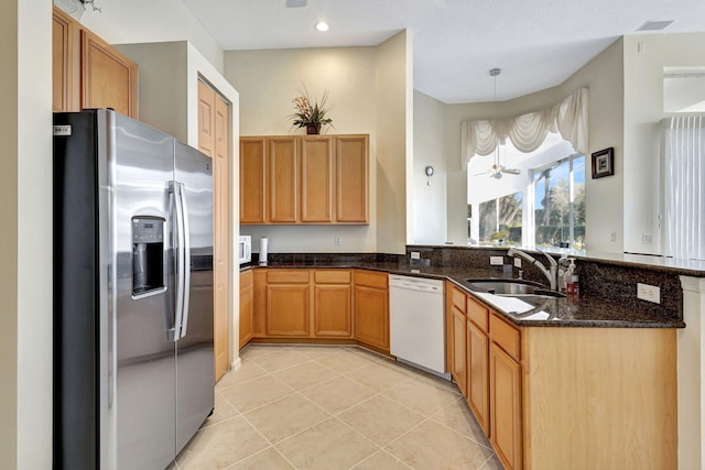 kitchen with pendant lighting, dark stone countertops, light tile patterned floors, white dishwasher, and stainless steel fridge with ice dispenser