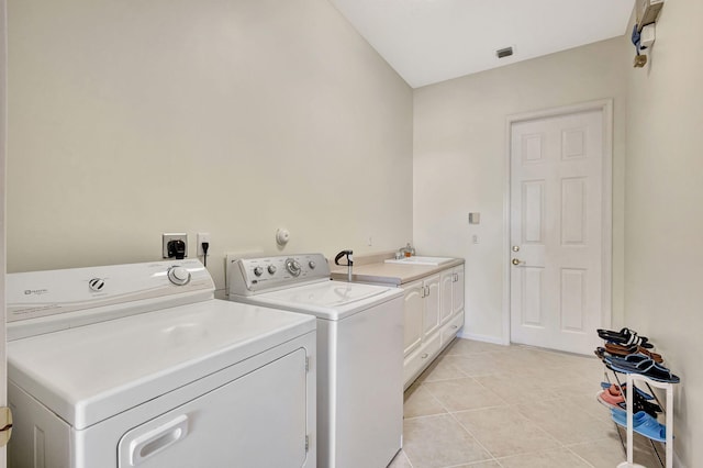 washroom with cabinets, light tile patterned flooring, sink, and washer and clothes dryer