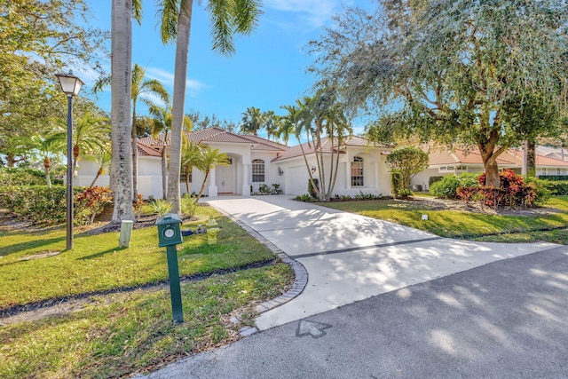 mediterranean / spanish-style home featuring a garage and a front yard