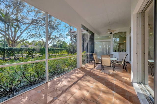 sunroom / solarium featuring a healthy amount of sunlight and ceiling fan