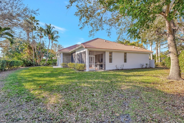 back of property featuring a yard and a sunroom