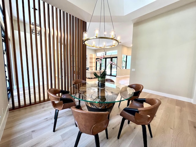 dining area featuring an inviting chandelier, baseboards, and wood finished floors