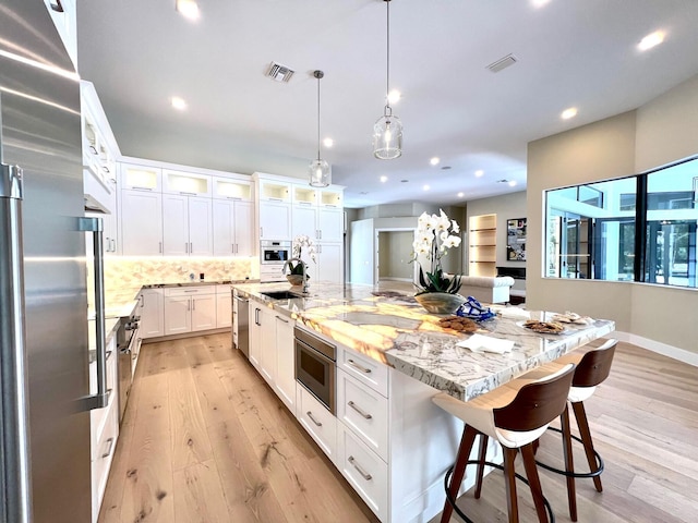 kitchen featuring white cabinets, light wood finished floors, visible vents, and stainless steel appliances