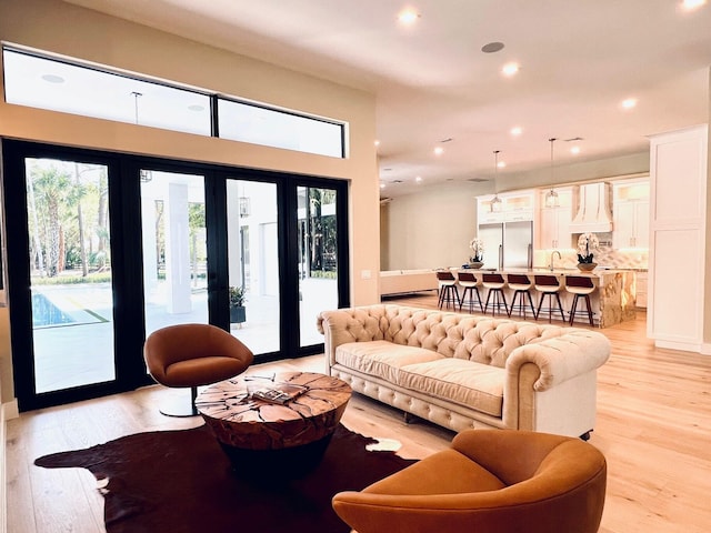 living area with recessed lighting and light wood-style floors