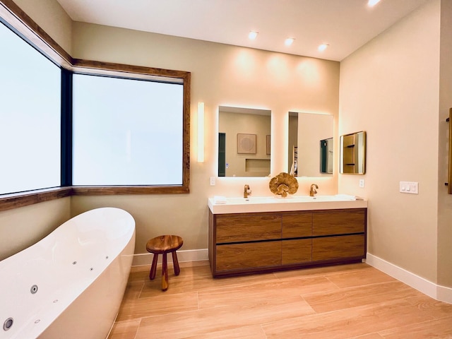 bathroom featuring double vanity, baseboards, a soaking tub, wood finished floors, and a sink