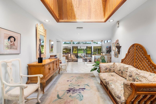 living area featuring light tile patterned floors and a towering ceiling