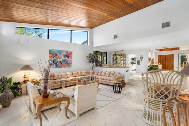 living room featuring a towering ceiling and wood ceiling