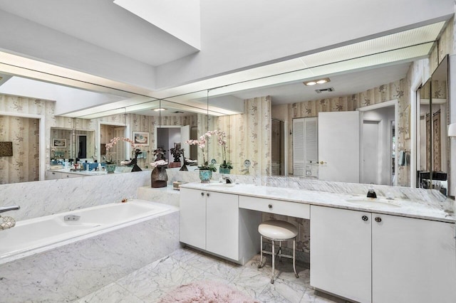 bathroom with vanity and tiled tub