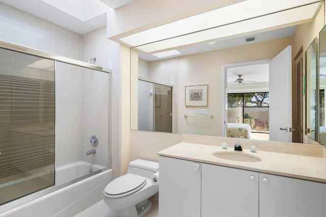 full bathroom with a skylight, enclosed tub / shower combo, vanity, and toilet