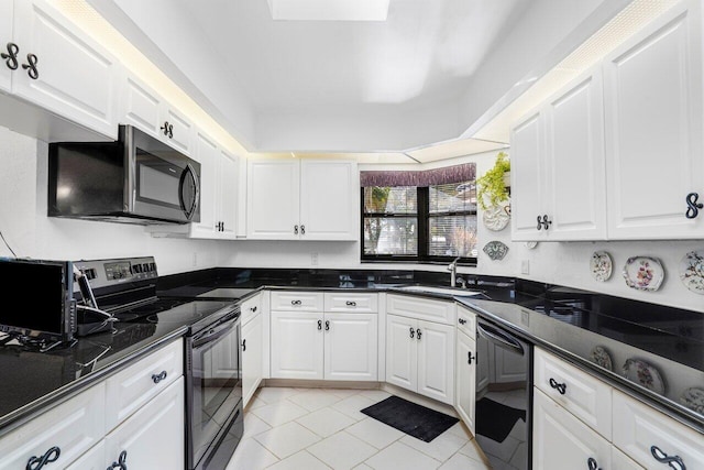 kitchen featuring sink, light tile patterned floors, dark stone countertops, black appliances, and white cabinets