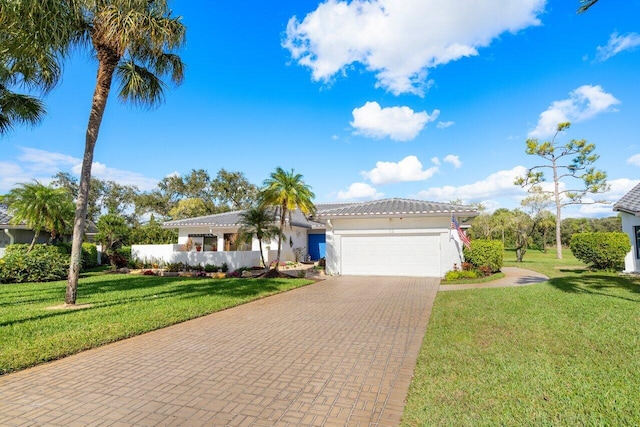 mediterranean / spanish house featuring a garage and a front yard