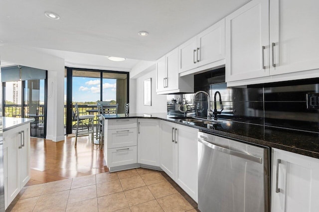 kitchen featuring sink, light tile patterned floors, stainless steel dishwasher, and white cabinets