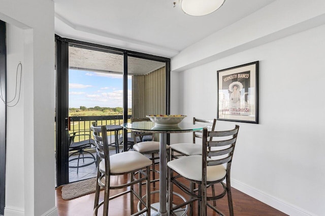 dining space featuring dark wood-type flooring and floor to ceiling windows