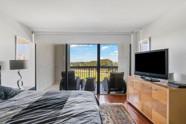 bedroom featuring wood-type flooring and access to outside