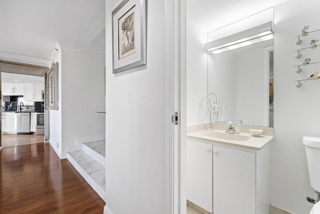 bathroom featuring vanity, wood-type flooring, ornamental molding, and toilet