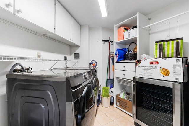 laundry area with wine cooler, light tile patterned floors, cabinets, and independent washer and dryer