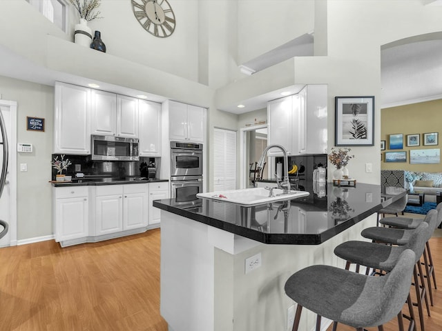 kitchen with white cabinetry, stainless steel appliances, and kitchen peninsula