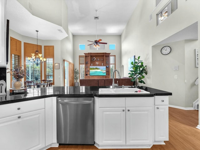 kitchen featuring dishwasher, sink, white cabinets, light hardwood / wood-style floors, and kitchen peninsula