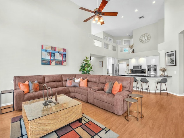 living room featuring light hardwood / wood-style flooring and ceiling fan