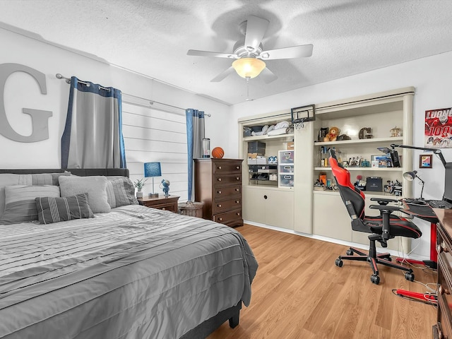 bedroom featuring ceiling fan, light hardwood / wood-style floors, and a textured ceiling