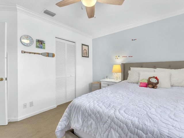 carpeted bedroom featuring ornamental molding, ceiling fan, and a closet