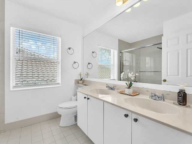 bathroom featuring vanity, toilet, tile patterned floors, and a shower with shower door