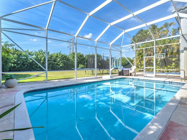 view of swimming pool featuring a patio area and glass enclosure