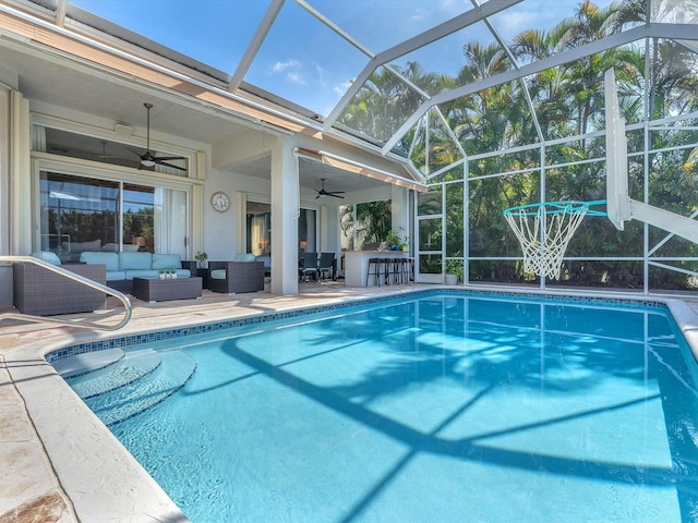 view of pool featuring outdoor lounge area, a lanai, an outdoor bar, ceiling fan, and a patio area