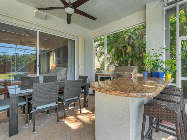 view of patio featuring a bar, grilling area, and ceiling fan