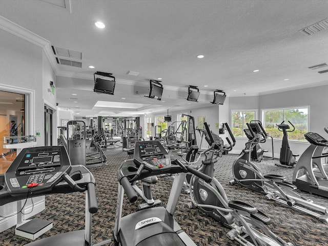 gym featuring ornamental molding, a textured ceiling, and carpet flooring