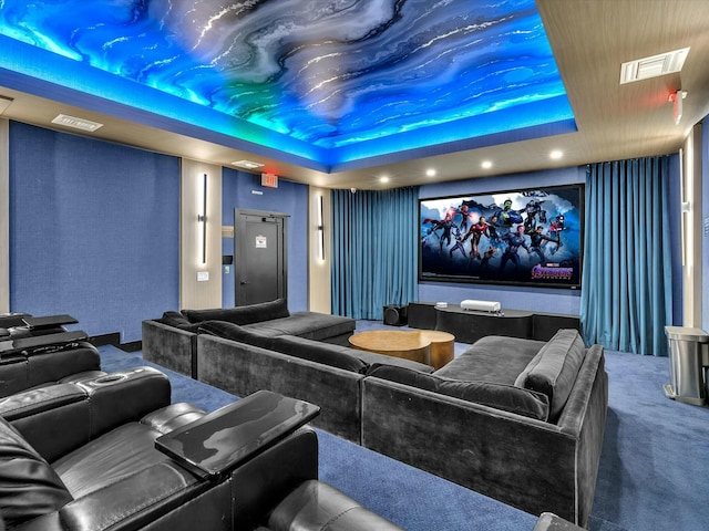 carpeted cinema with a raised ceiling