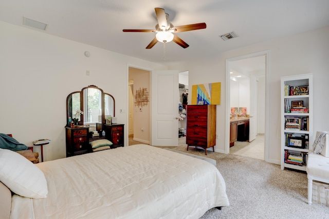 bedroom featuring ceiling fan, ensuite bath, and light carpet