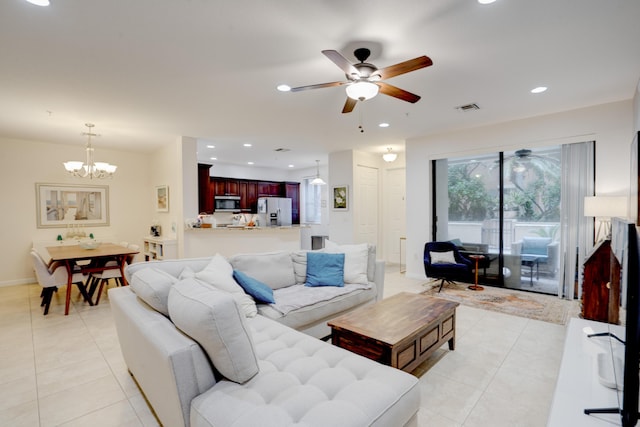 tiled living room with ceiling fan with notable chandelier