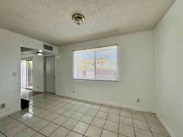 tiled spare room with ornamental molding, plenty of natural light, and a textured ceiling